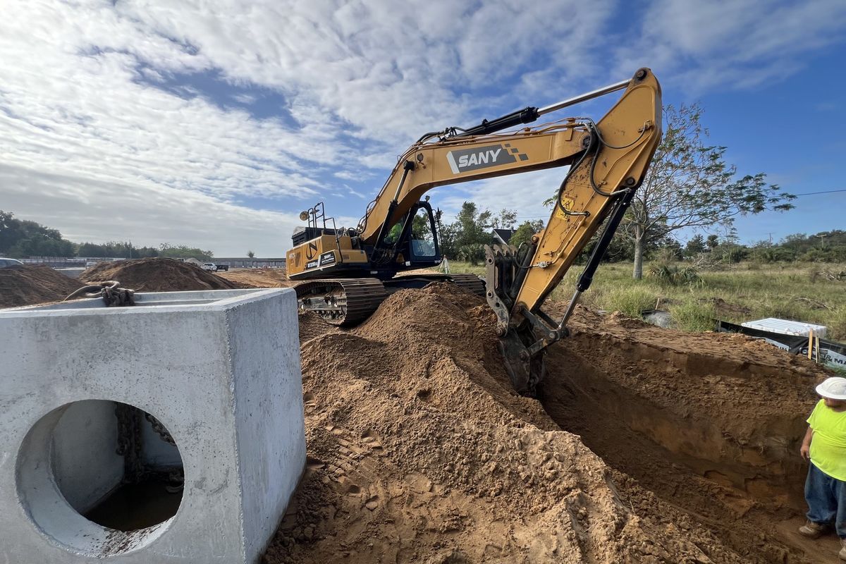 Precast box culvert set beside an open excavation on a Central Florida site