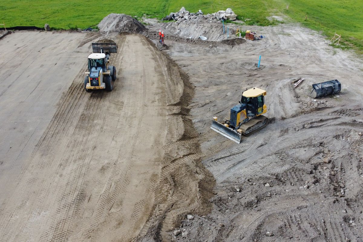 Aerial view of a loader and dozer shaping a retention pond
