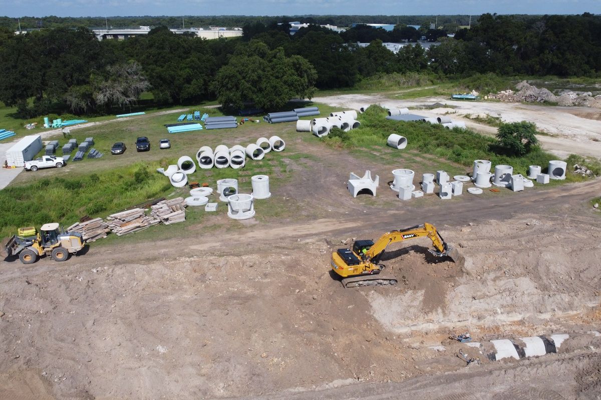 Aerial view of a materials yard stocked with concrete structures and pipe